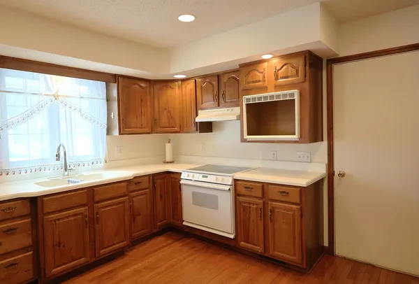 a kitchen with a sink cabinets and wooden floor