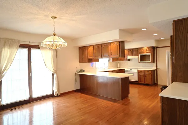 a kitchen with stainless steel appliances granite countertop a sink a stove and a wooden floors