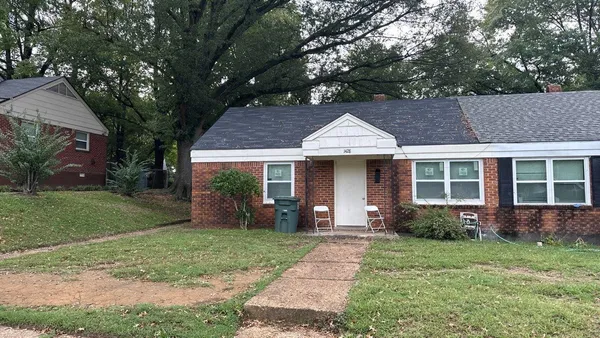 a front view of a house with a garden and plants