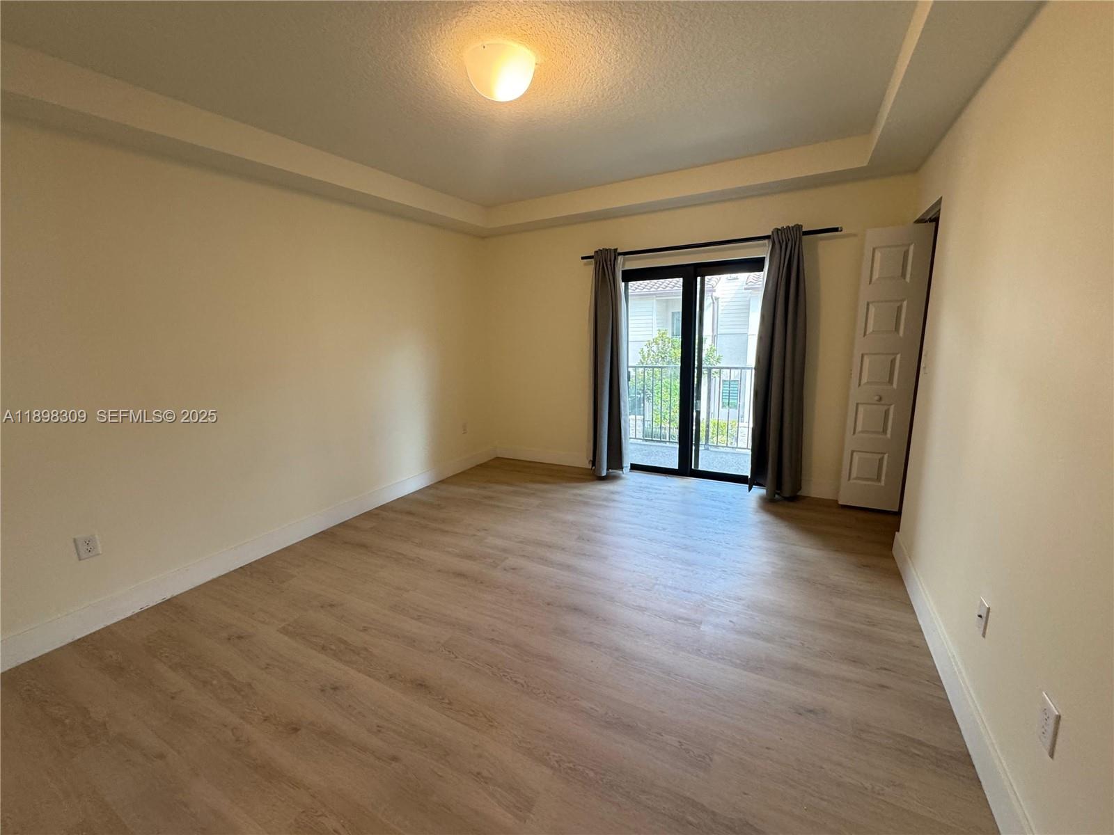 4802 Northwest 83rd Path Doral, FL 33166 - Photo 15 of 25 an empty room with wooden floor and windows