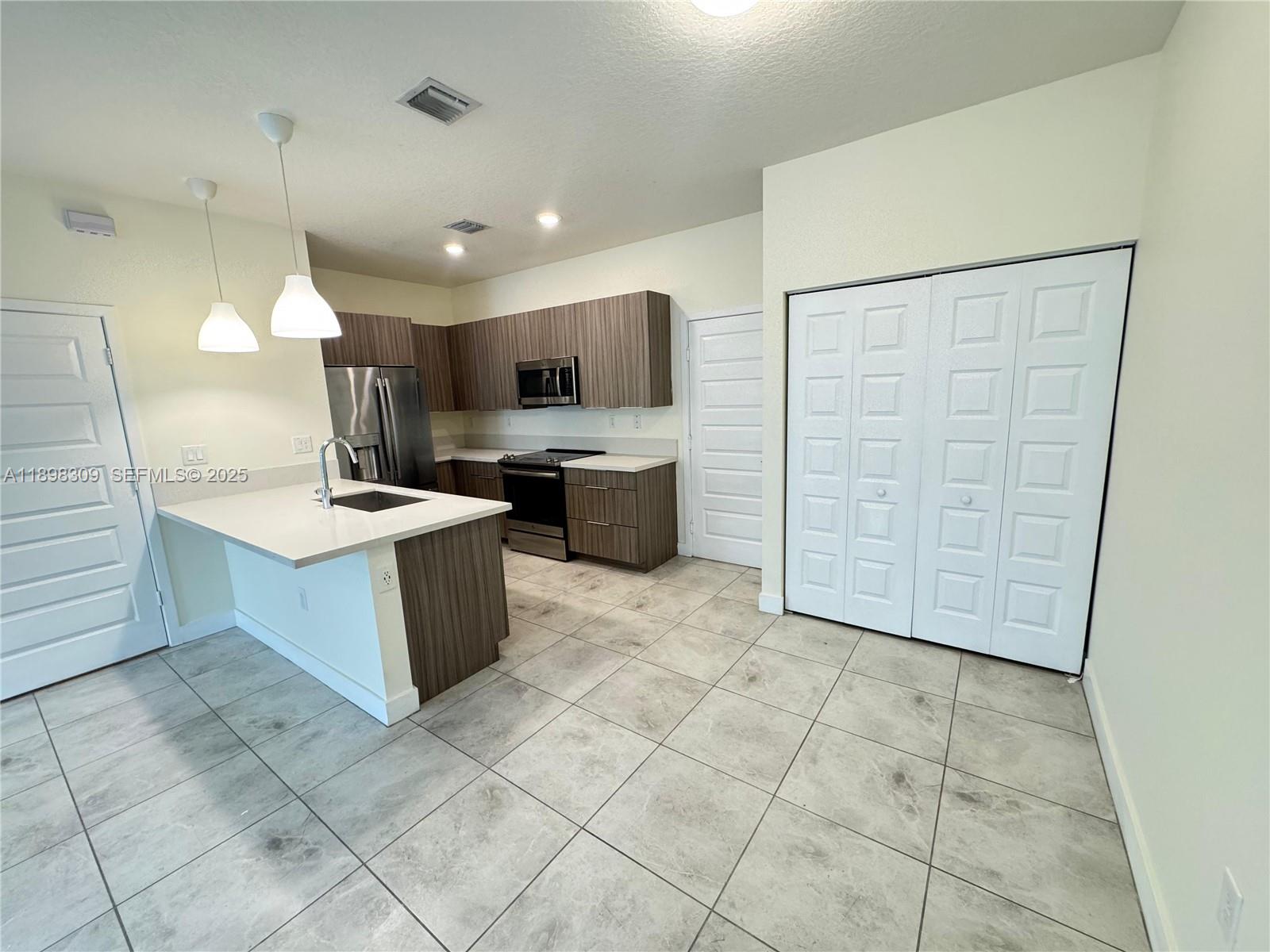 4802 Northwest 83rd Path Doral, FL 33166 - Photo 4 of 25 a large kitchen with a lot of counter space and a sink