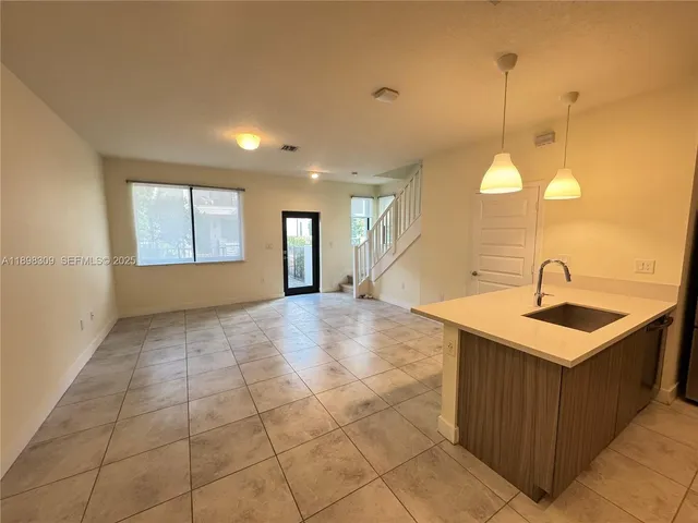 a view of a kitchen with a sink and a mirror