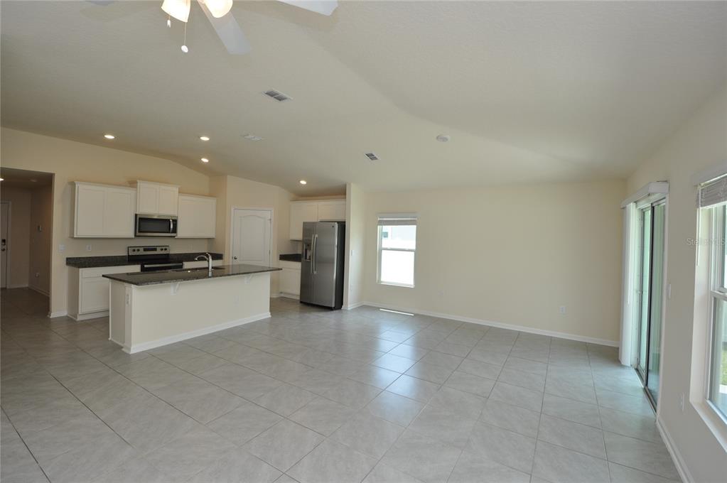 80 Oakleaf Way Palm Coast, FL 32137 - Photo 14 of 33 a large kitchen with stainless steel appliances kitchen island granite countertop a stove a sink and a refrigerator