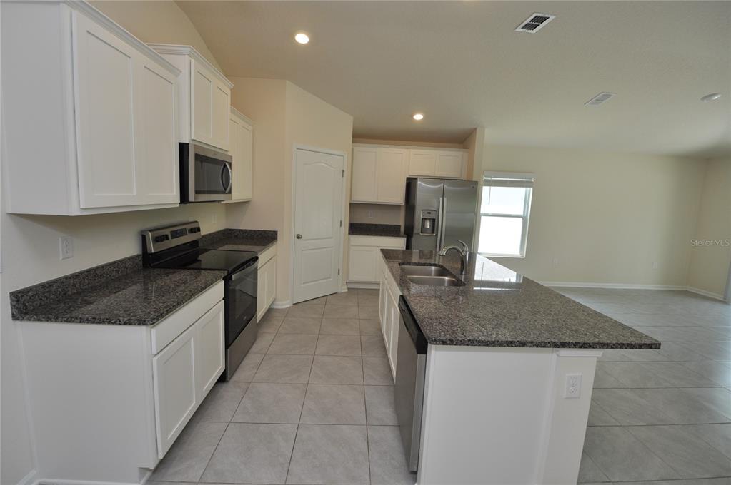 80 Oakleaf Way Palm Coast, FL 32137 - Photo 5 of 33 a kitchen with stainless steel appliances granite countertop a sink stove and cabinets