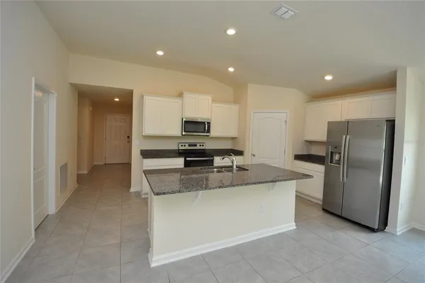 a kitchen with stainless steel appliances granite countertop a refrigerator and a stove