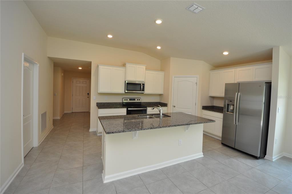 80 Oakleaf Way Palm Coast, FL 32137 - Photo 6 of 33 a kitchen with stainless steel appliances granite countertop a refrigerator and a stove