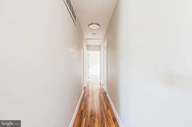 a view of a hallway with wooden floor