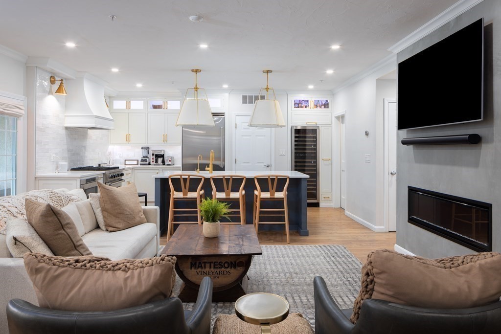 209 Victory Road, Unit 209 Quincy, MA 02171 - Photo 3 of 17 a living room with furniture a flat screen tv and a fireplace