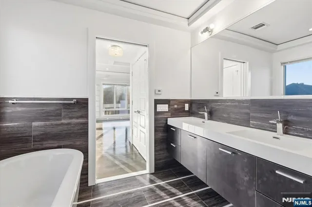 a bathroom with a sink a bathtub and a mirror