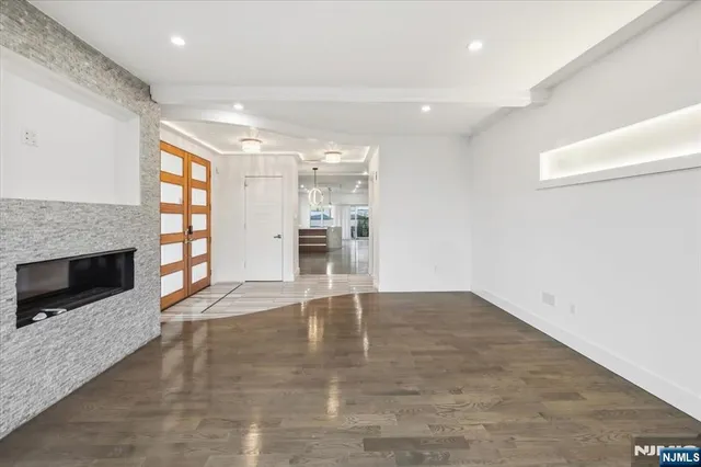 an empty room with windows and fireplace