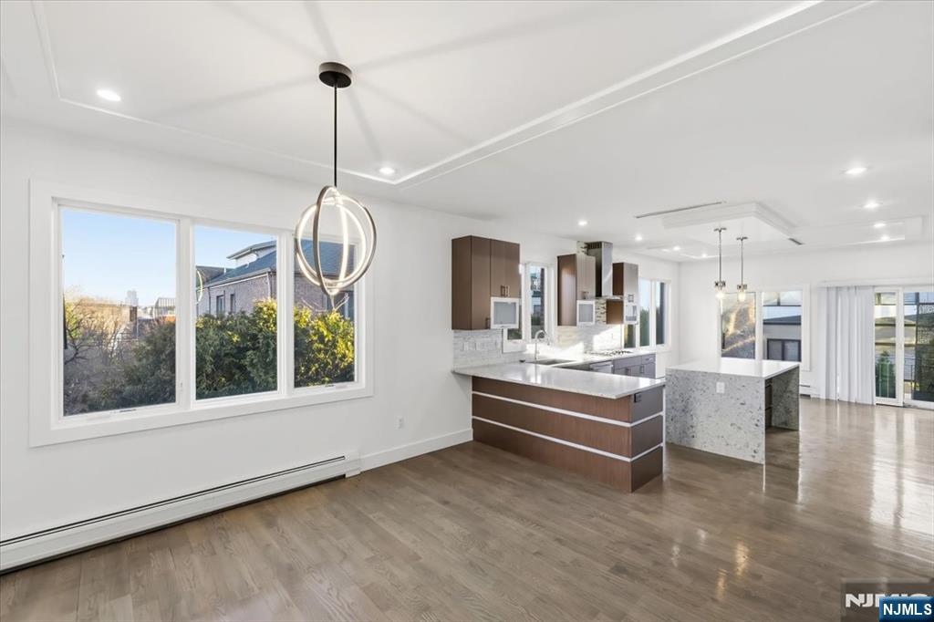 12 Orchard Street, Unit 12 Edgewater, NJ 07020 - Photo 30 of 33 a room with lots of wooden furniture and a chandelier