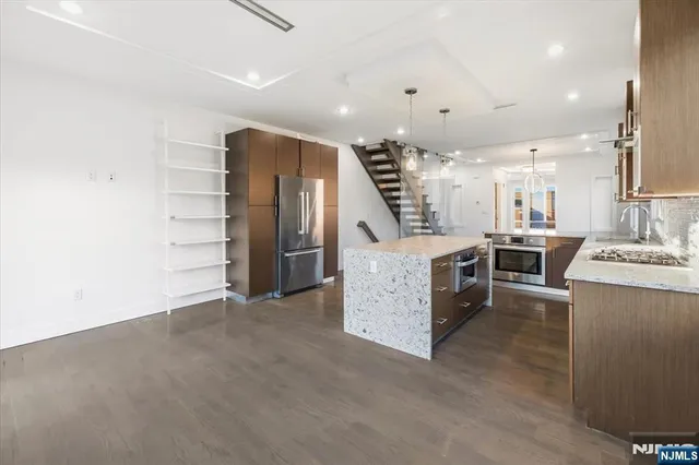 a view of a kitchen with furniture and stainless steel appliances