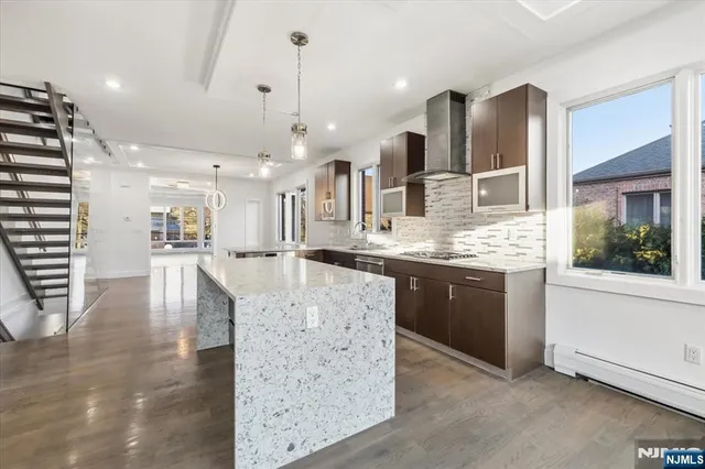 a large kitchen with kitchen island a sink stainless steel appliances and cabinets