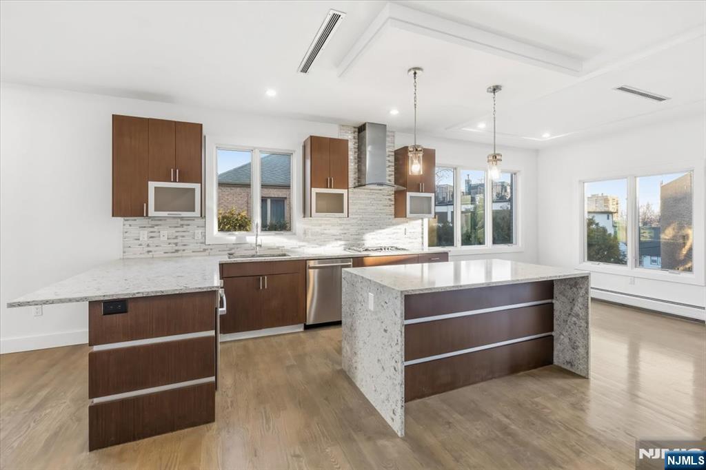 12 Orchard Street, Unit 12 Edgewater, NJ 07020 - Photo 5 of 33 a large kitchen with stainless steel appliances kitchen island granite countertop a stove and a sink