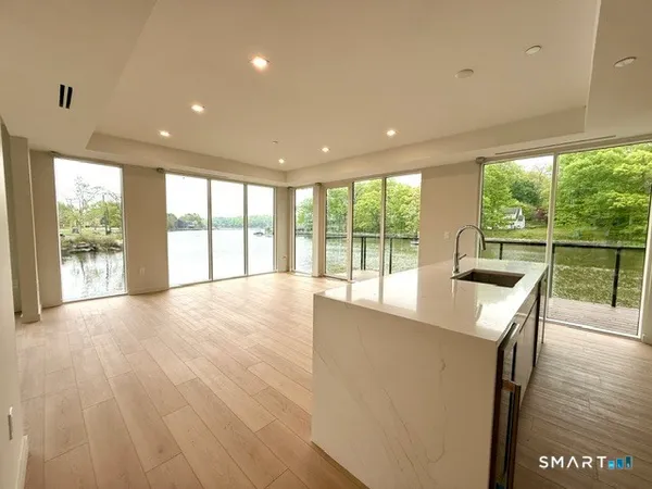 a view of an empty room with wooden floor and a floor to ceiling window