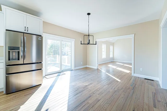 a view of a kitchen with wooden floor and a refrigerator