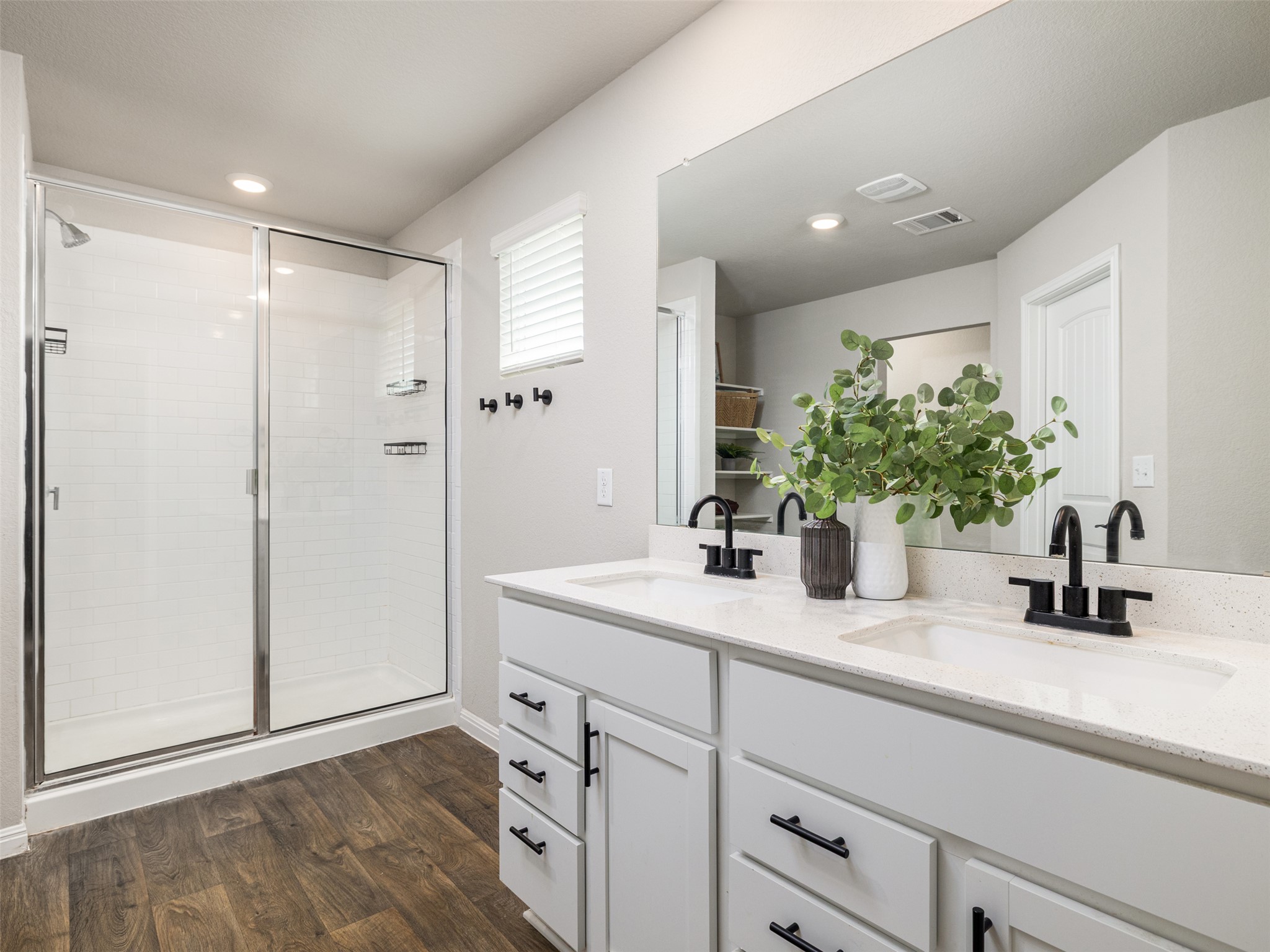 439 Hunter Loop Bertram, TX 78605 - Photo 15 of 23 Double vanity sinks and a glass-enclosed shower create a practical, elegant bathing space.