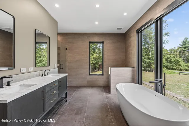 a bathroom with a bathtub sink and mirror