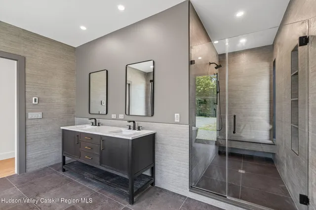 a bathroom with a double vanity sink a toilet and shower