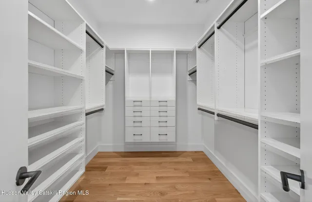 a view of walk in closet with empty racks