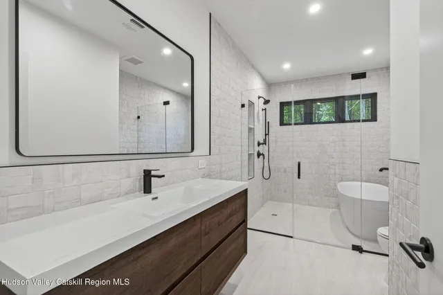a bathroom with a double vanity sink a mirror and a bathtub
