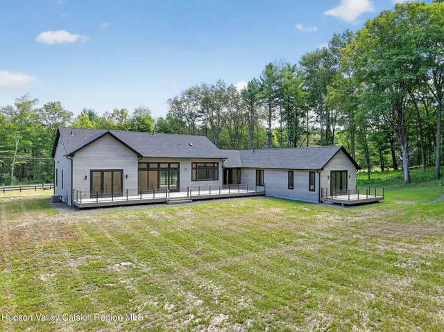 a front view of a house with yard and green space