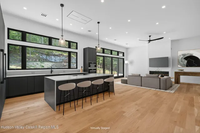 a large kitchen with kitchen island a large window and stainless steel appliances