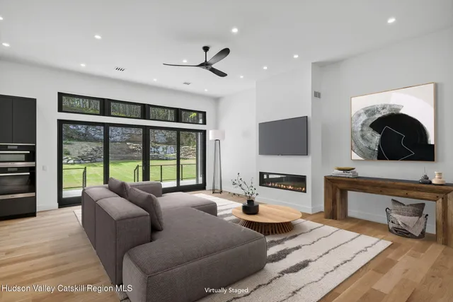 a living room with furniture a flat screen tv and a fireplace