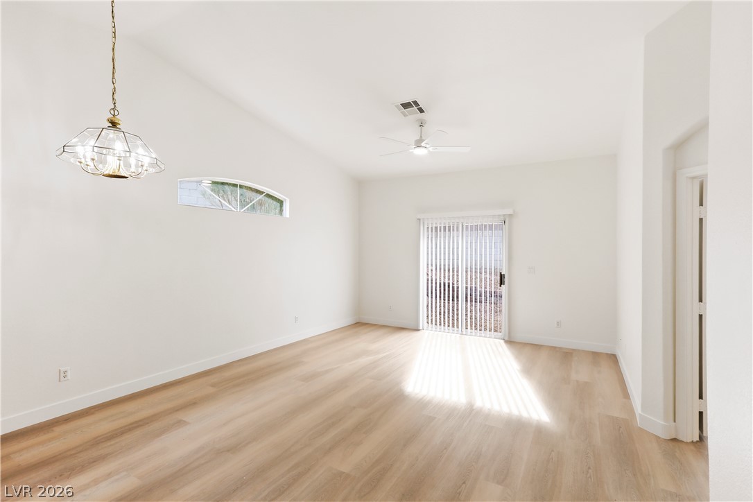 1134 Evening Ridge Street Henderson, NV 89052 - Photo 6 of 35 A well-lit living space with vaulted ceilings and beautiful wood flooring.