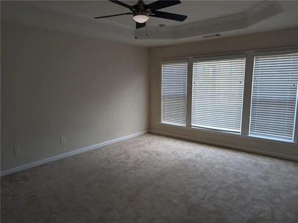 an empty room with a ceiling fan and window
