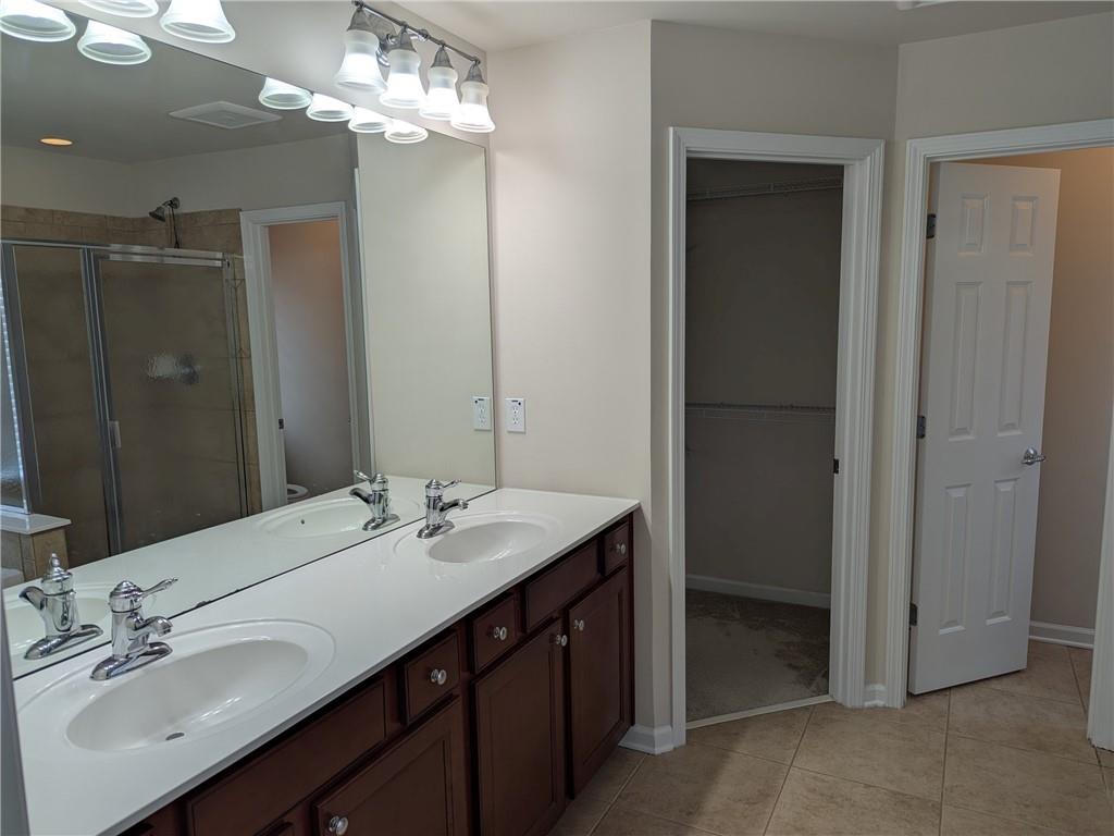 430 Floral Place Suwanee, GA 30024 - Photo 22 of 26 a bathroom with a sink double vanity and a mirror
