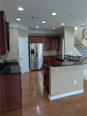 a kitchen with stainless steel appliances granite countertop a refrigerator and a stove top oven