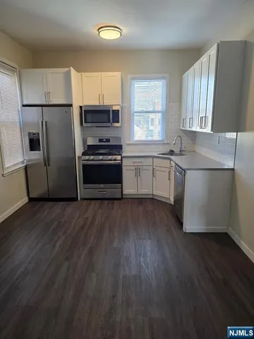 a kitchen with a wooden floor and a stove top oven