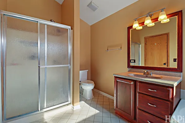 a bathroom with a toilet sink vanity and mirror