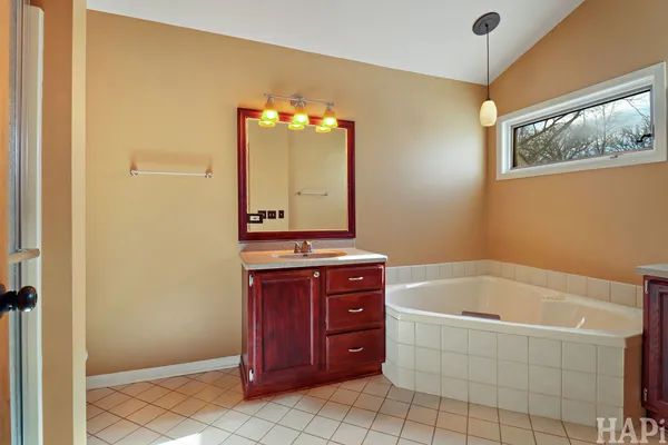 a bathroom with a tub sink and mirror