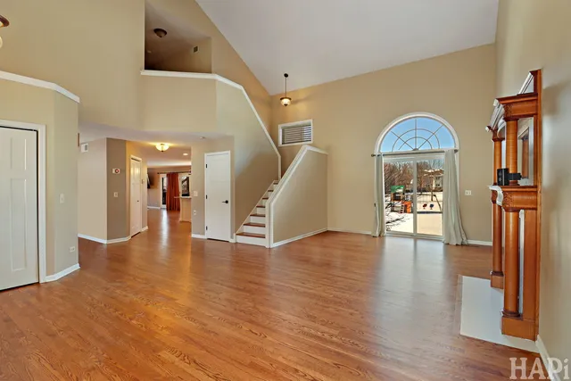 a view of a livingroom with wooden floor and stairs