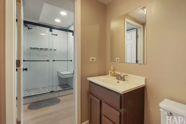 a bathroom with a sink a toilet and shower