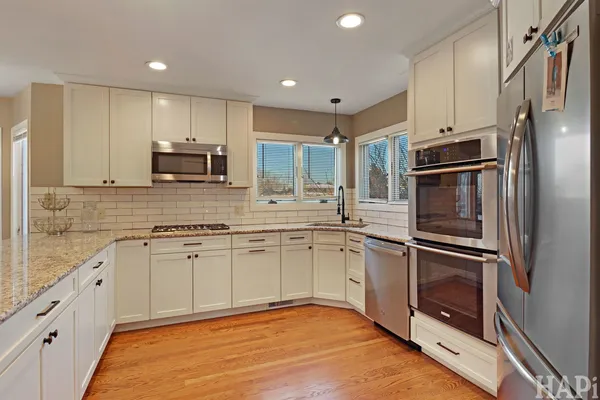 a kitchen with stainless steel appliances granite countertop a refrigerator and a stove top oven