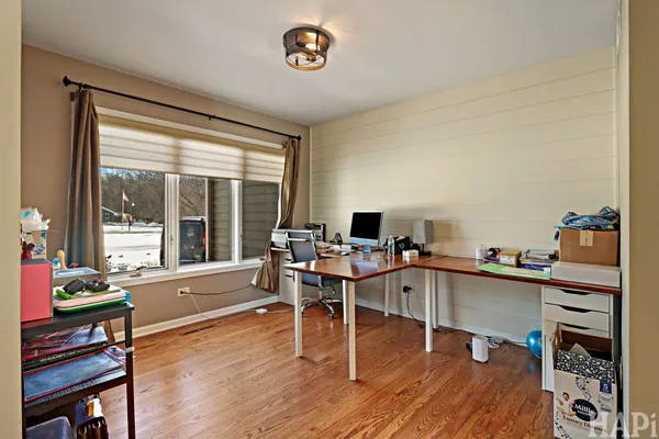 a view of a workspace with furniture and a window