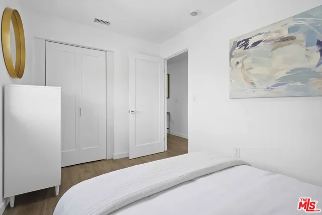 a bedroom with a bed and a painting on the wall