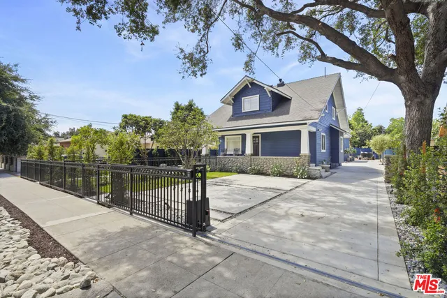 a front view of a house with a yard and potted plants