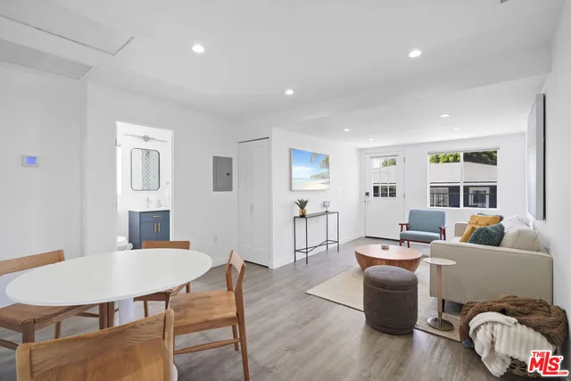 a living room with furniture two window and wooden floor