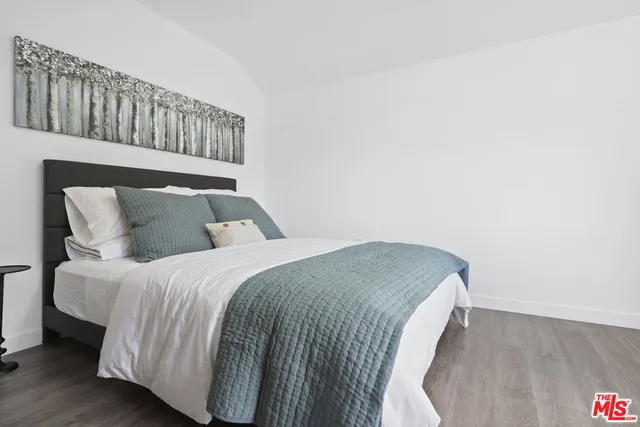 a bed sitting in a bedroom next to a wooden cabinet
