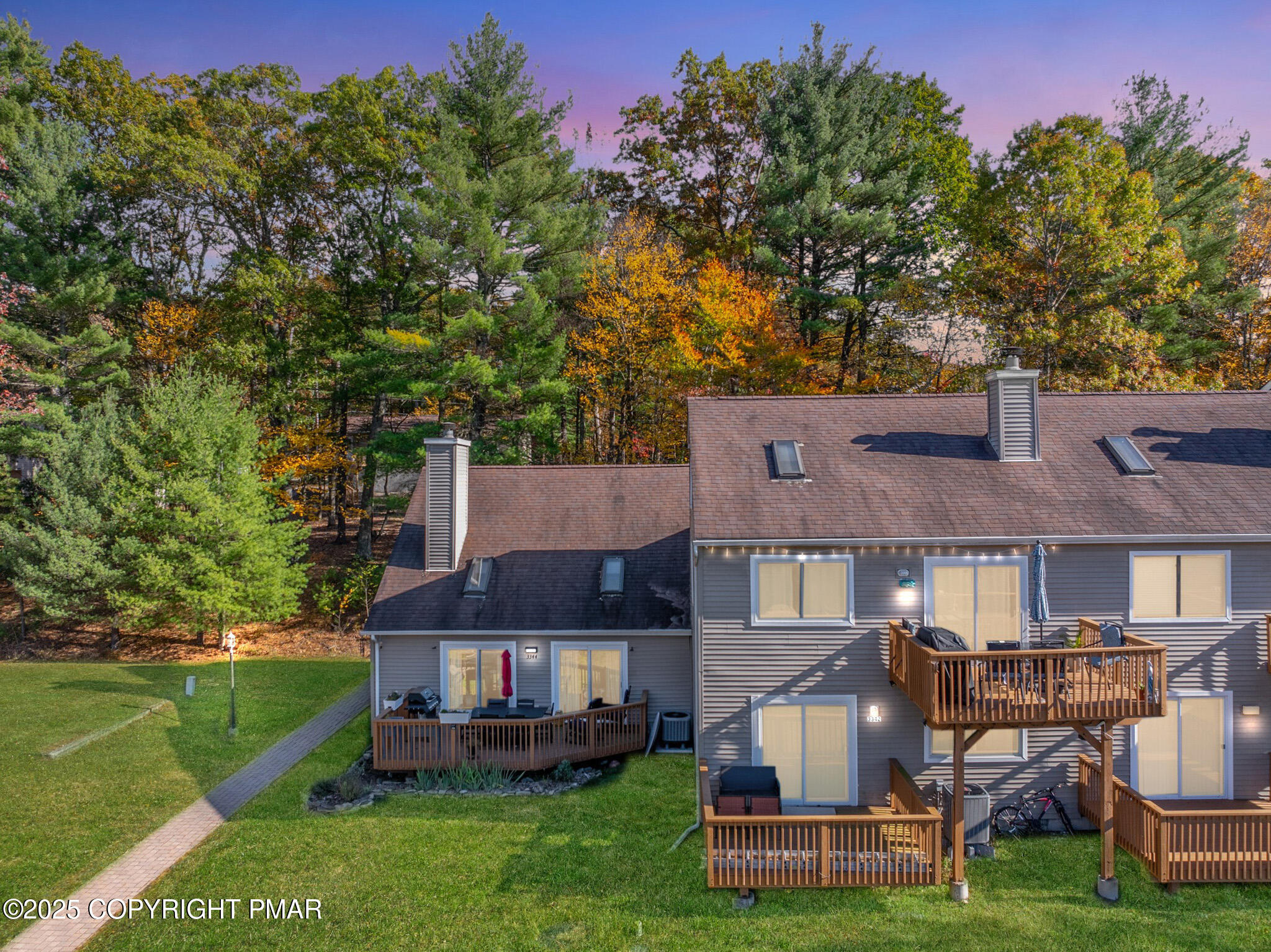a front view of a house with a garden and trees