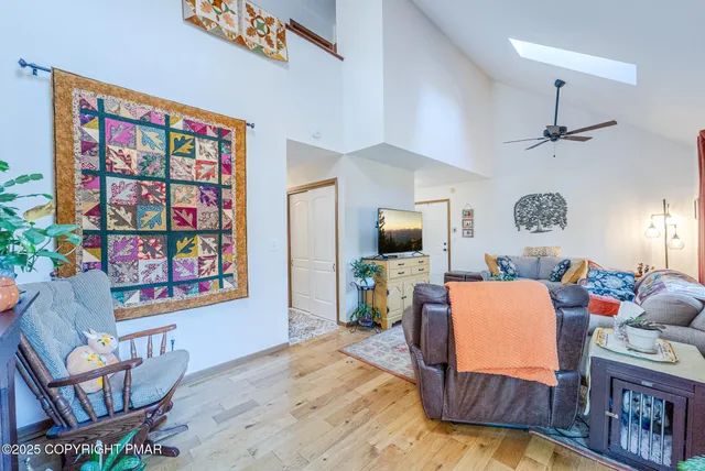 a living room with furniture a flat screen tv and a wall paintings