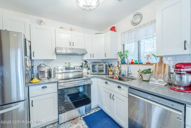 a kitchen with kitchen island granite countertop white cabinets and white appliances
