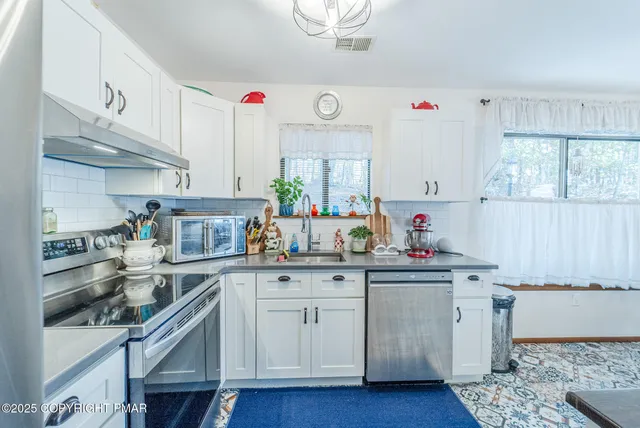 a kitchen with stainless steel appliances granite countertop a sink and cabinets