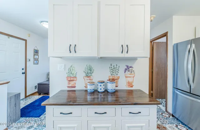 a kitchen with stainless steel appliances granite countertop a refrigerator a stove and white cabinets