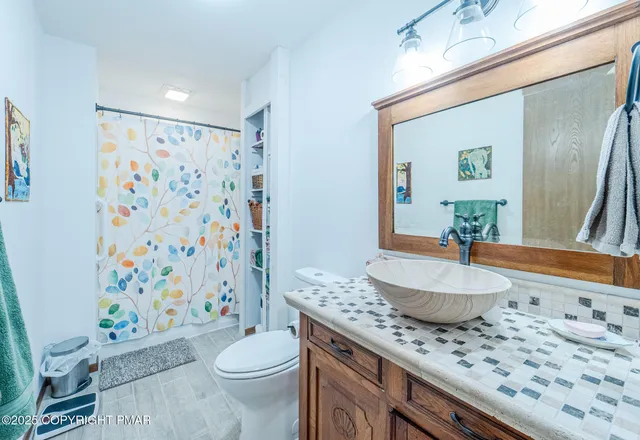 a bathroom with a granite countertop toilet sink and mirror