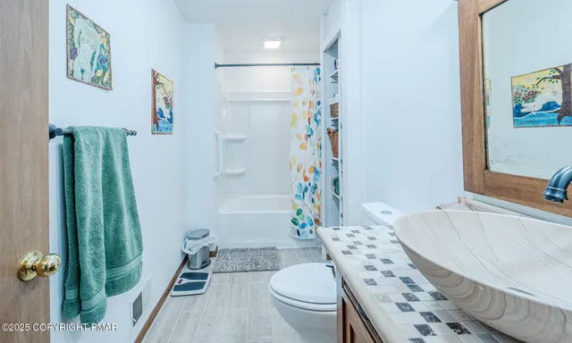 a bathroom with a sink toilet and shower